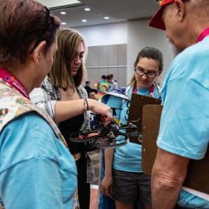 Students and DI Appraisers examine the team's drone in a Technical challenge
